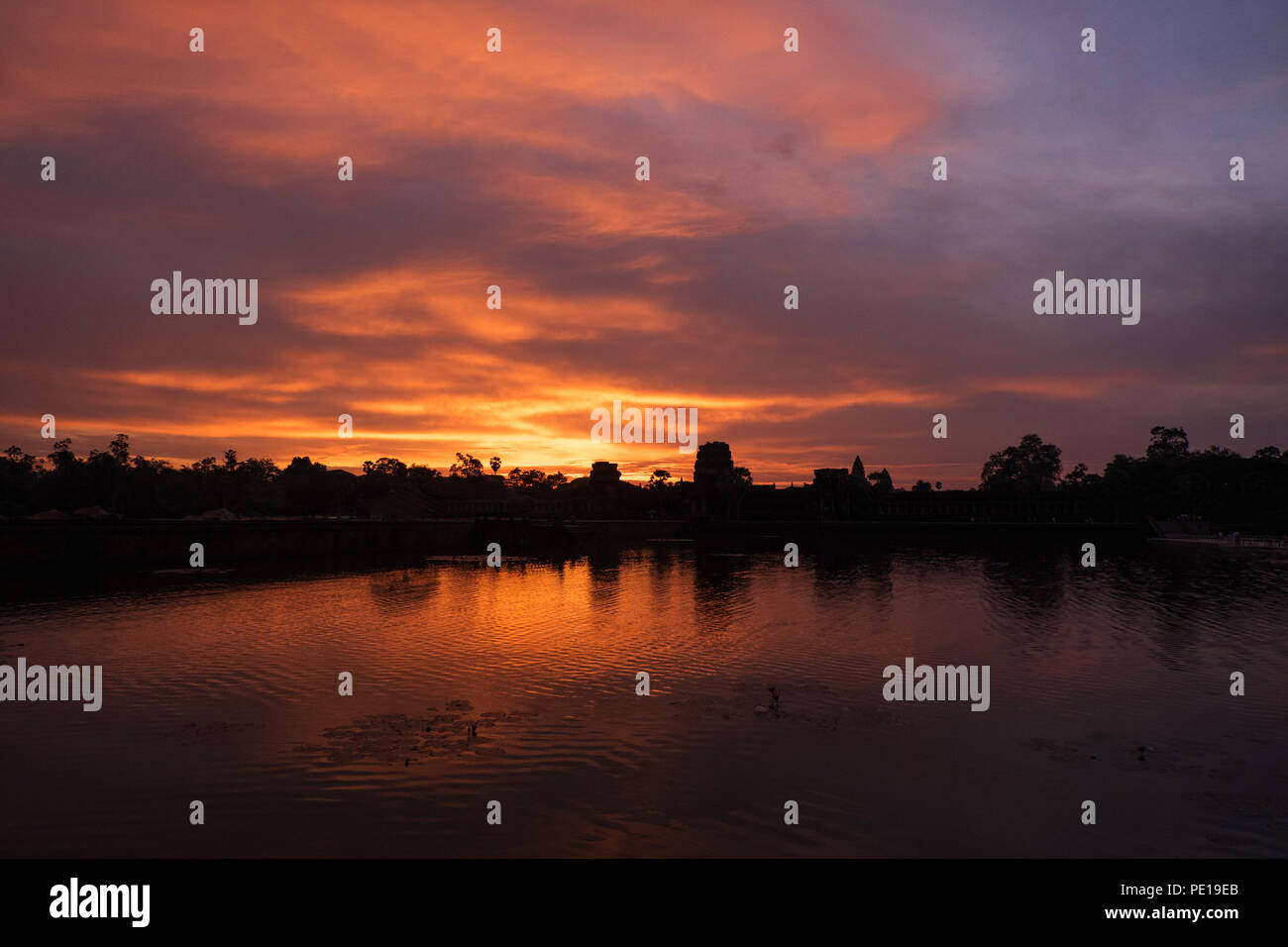 Amanecer sobre el foso que rodea el templo Angkor Wat, el monumento religioso más grande en el mundo - cerca de Siem Reap, Camboya Foto de stock