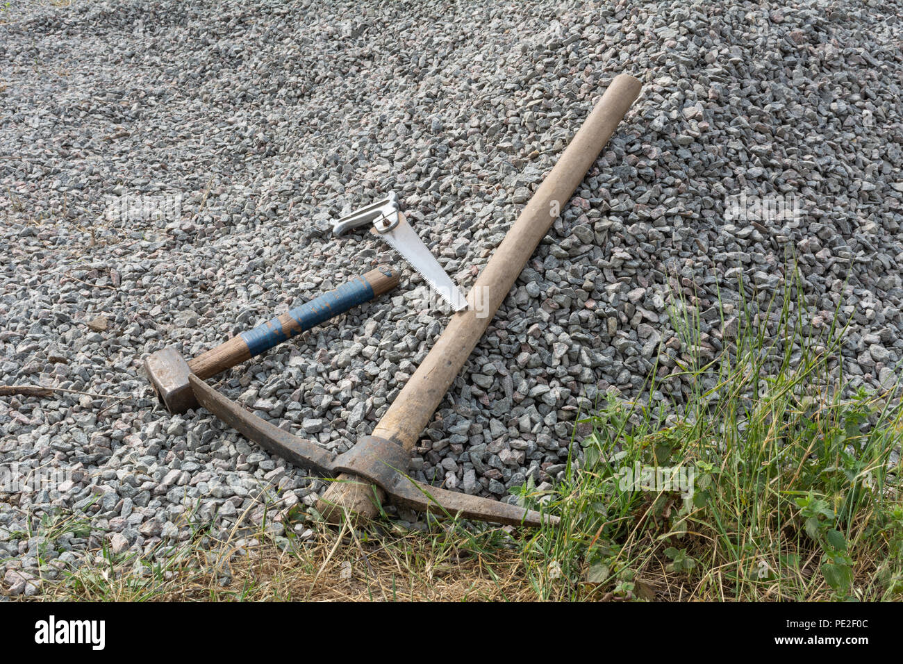 Herramientas de construcción: Sierra, recogida y martillo sobre grava Foto de stock
