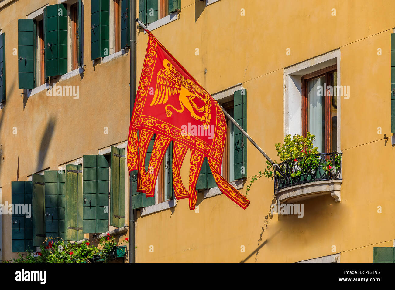 Bandera tradicional Veneciano con el León de San Marcos en la fachada de un edificio en la ciudad de Venecia, Italia Foto de stock