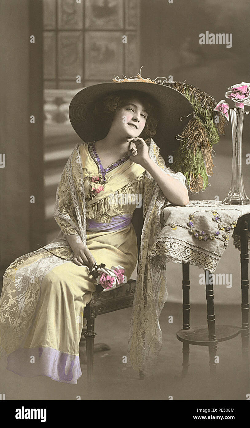Vintage, tintado a mano de estilo eduardiano, sepia, mostrando la postal de una bella mujer en una imagen sombrero. Foto de stock