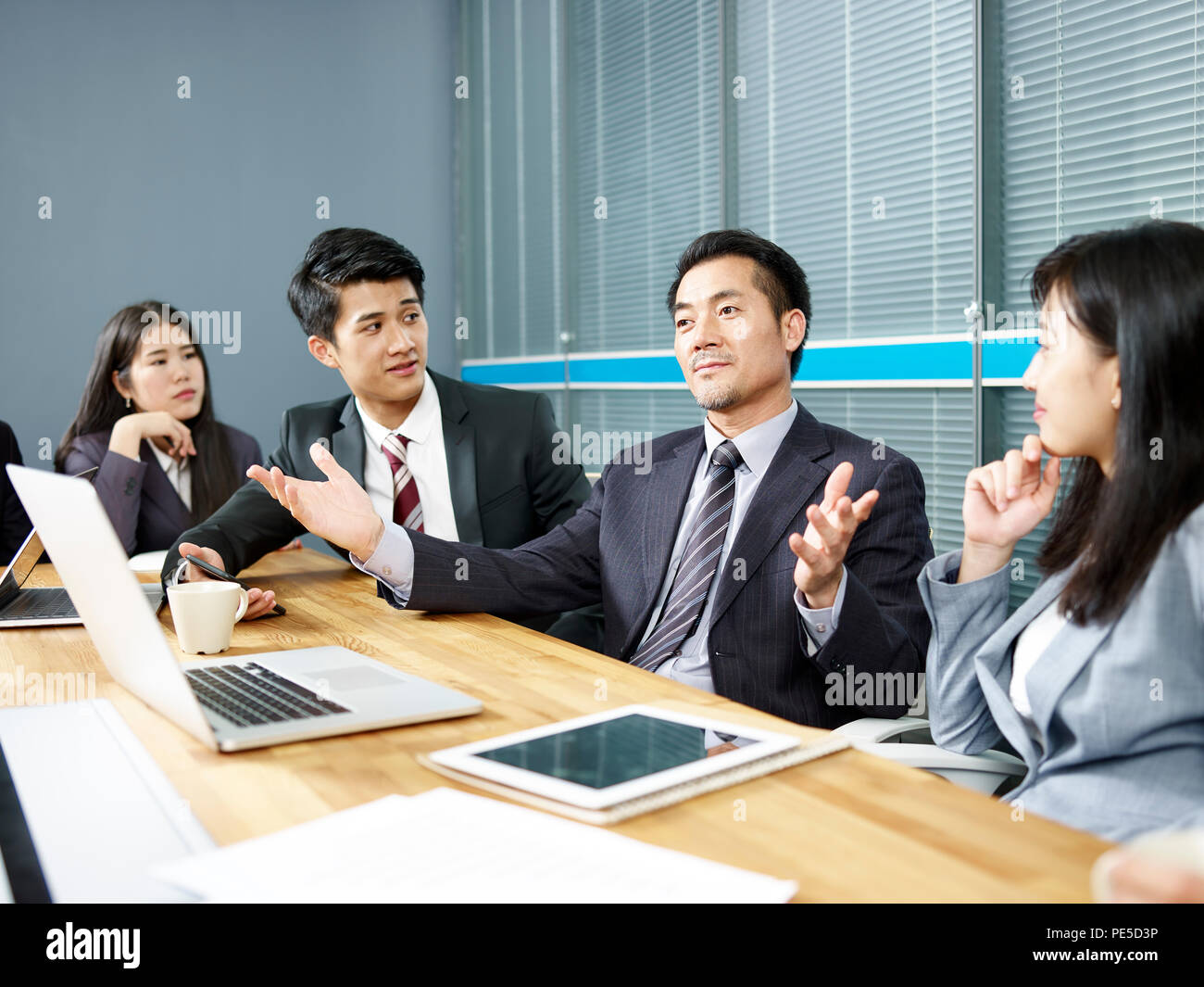 Ejecutivo corporativo de Asia y su equipo empresarial reunión y negociación con el cliente. Foto de stock