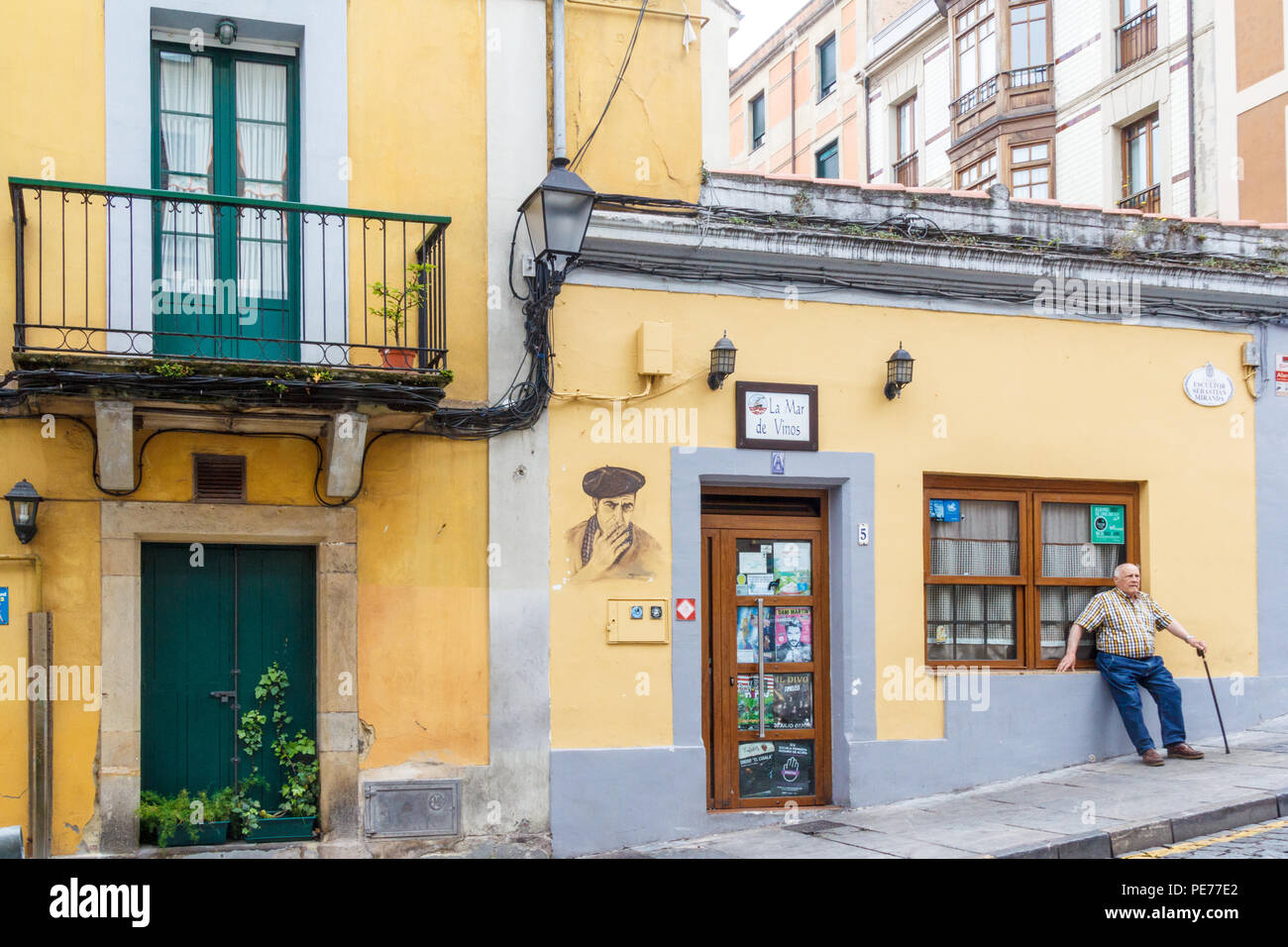 Gijón, España - 6 de julio de 2018: el hombre con bastón descansa después de caminar cuesta arriba en el antiguo barrio de pescadores. La zona es conocida como Cimadevilla Foto de stock