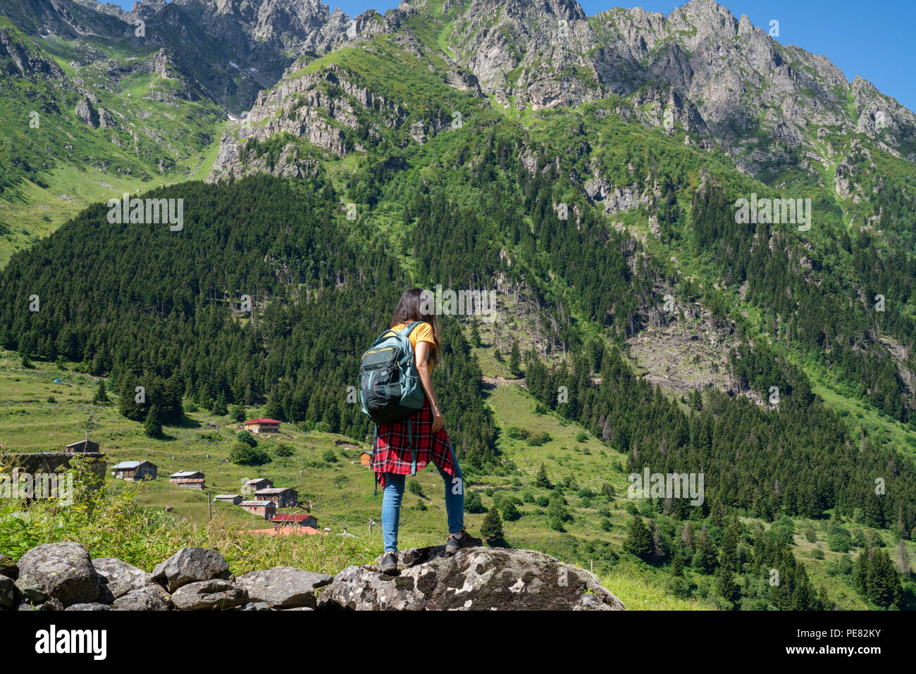 joven mujer de senderismo de pie en la roca superior, mujer mochila mirando  el hermoso valle