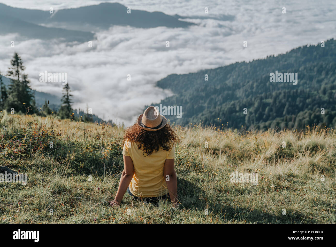 Mujer viajero hipster deseando en increíbles montañas y Valley View Foto de stock