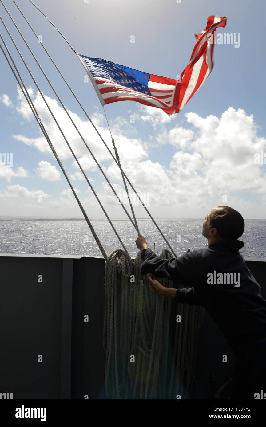 151113-N-BD393-089 OCÉANO PACÍFICO (Nov. 13, 2015) - Intendencia Seaman Anisia Guerrero, de San Antonio, iza la bandera americana en el portaaviones USS Theodore Roosevelt (CVN 71). Theodore Roosevelt está funcionando en los EE.UU. 3ª Flota zona de operaciones como parte de un despliegue global en ruta a su nueva embarcan en San Diego para completar un tres-carrier embarcan shift. (Ee.Uu. Navy photo by Mass Communication Specialist 3ª clase Emily A. Fischley/liberado) Foto de stock