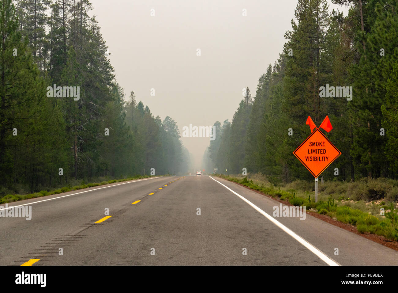 La autopista llena de humo de incendios en el sur de Oregon, firmar al lado de la carretera 'smoke' de visibilidad limitada. Foto de stock