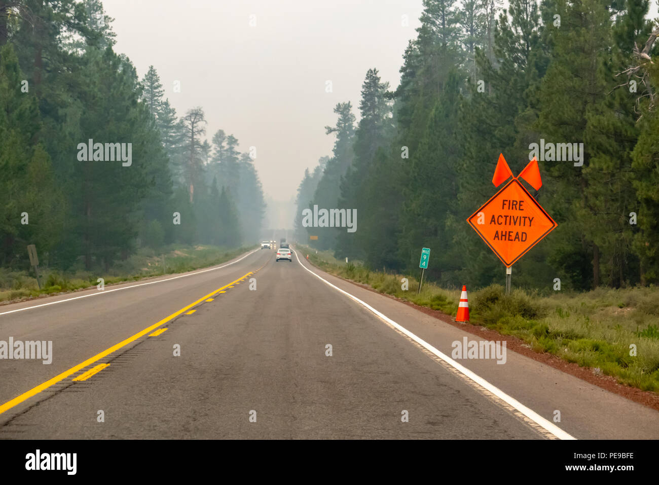 La autopista llena de humo de incendios en el sur de Oregon, firmar al lado de la carretera "actividad de incendios por delante". Foto de stock