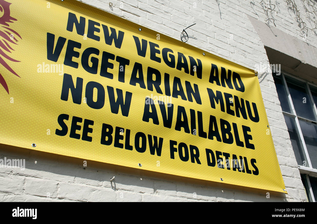 Banner fuera de un pub publicidad veganas y comida vegetariana. Foto de stock