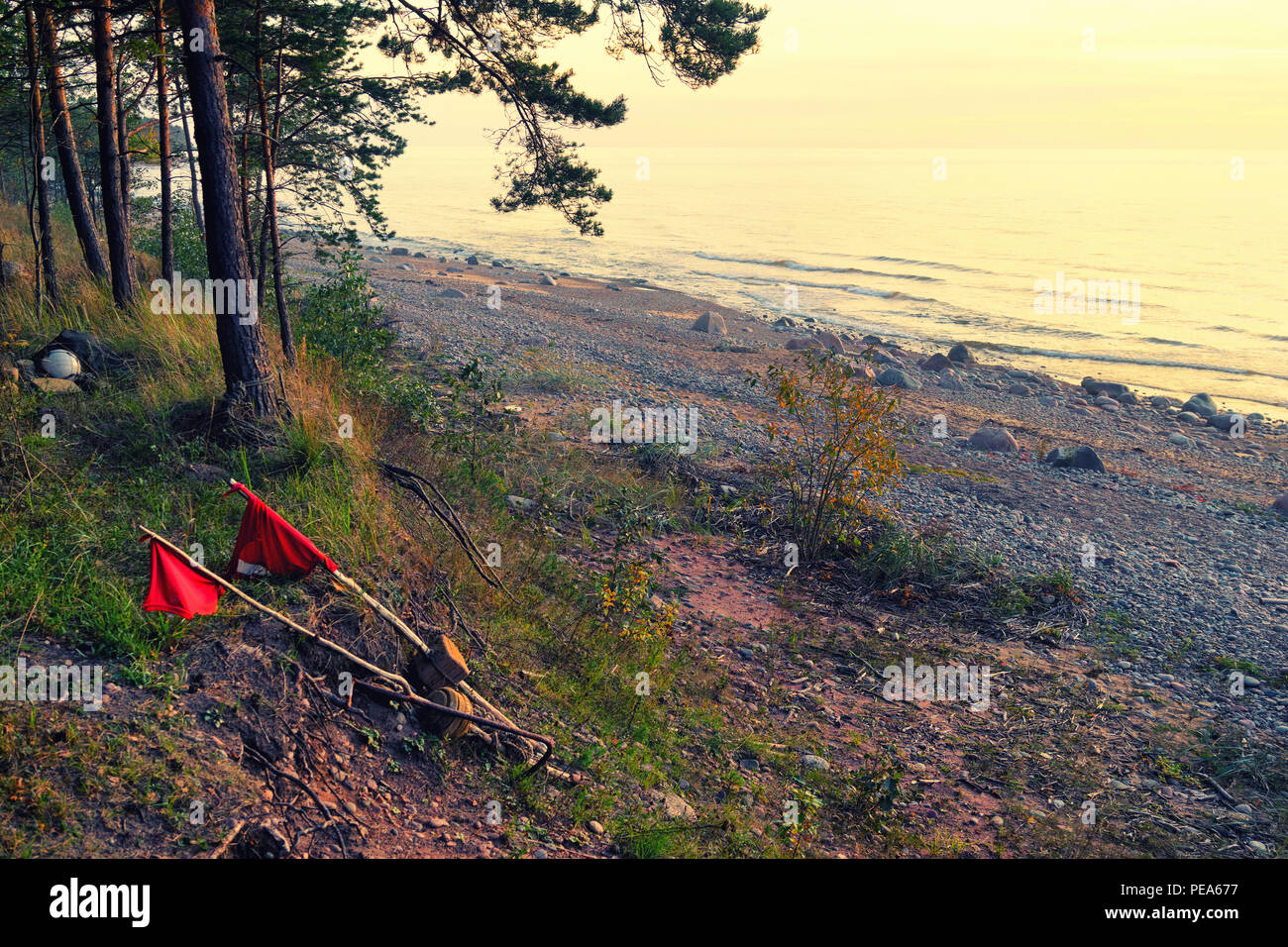 Banderas rojas sobre flotadores para redes de pesca se mecen en el viento del mar y olas pequeñas Foto de stock
