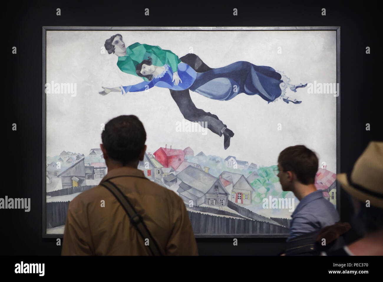Los visitantes delante de la pintura 'Over the Town' por el pintor modernista ruso Marc Chagall (1914-1918) que se muestra en la exposición del Centro Georges Pompidou de París, Francia. La exposición dedicada a la vanguardia rusa en Vitebsk (1918-1922) se extiende hasta el 16 de julio de 2018. Foto de stock