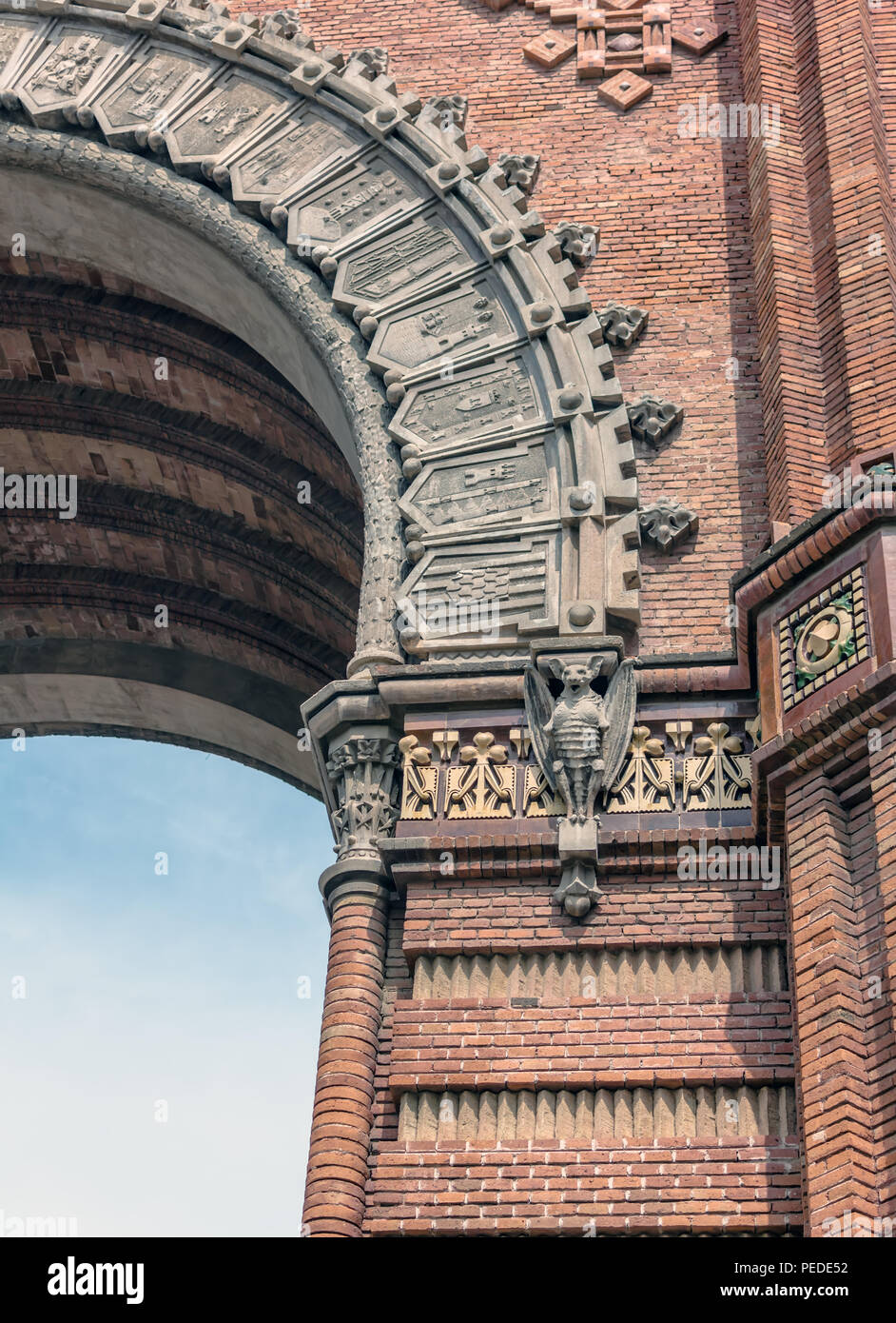 Los murciélagos de piedra sobre pilares de ladrillo rojo de la Arc de Triomf (arco de triunfo) en estilo Neo-Mudejar en Barcelona, España Foto de stock
