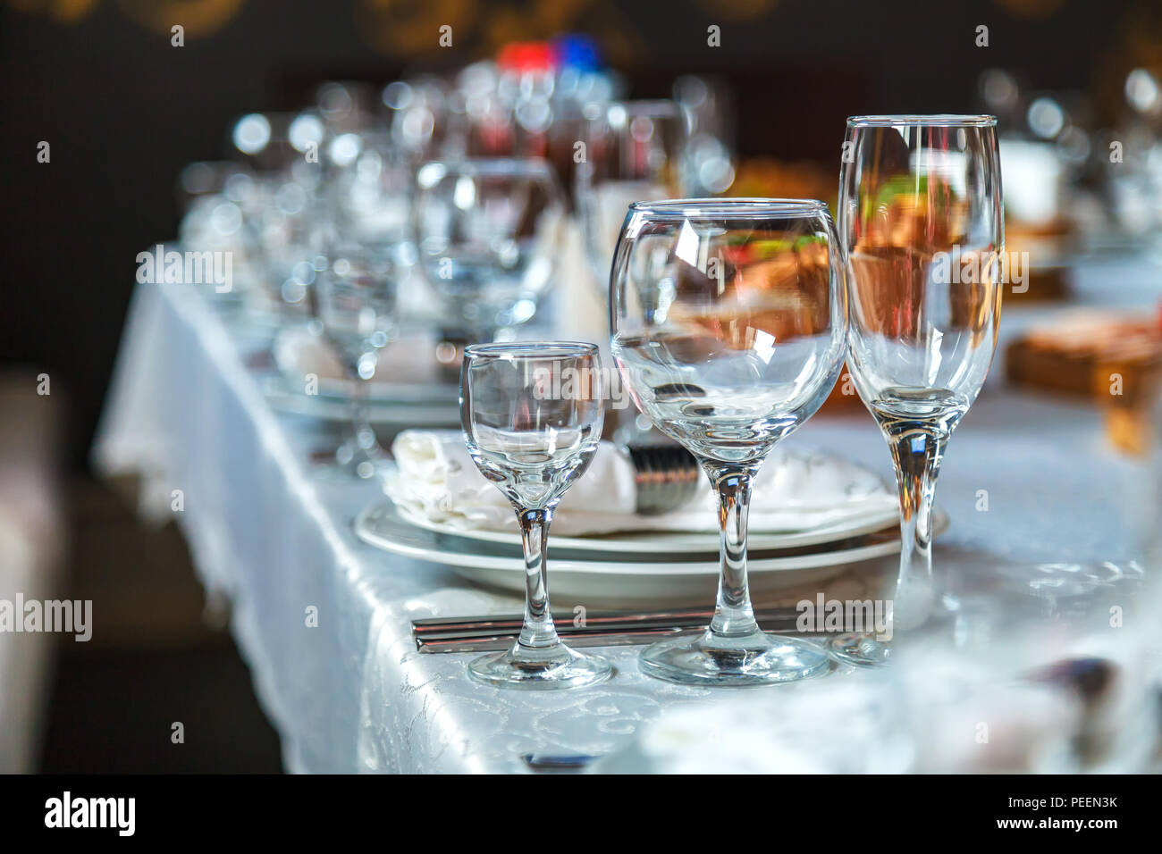 Porción de una mesa festiva con un vaso de copas de vino y una copa, y  también platos con servilletas sobre un mantel blanco Fotografía de stock -  Alamy