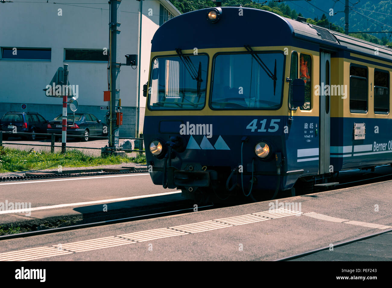 Wilderswil, en el Oberland bernés en Suiza - Agosto 5, 2017 : Azul - tren amarillo de la Berner Oberland-Bahn (BOB), llegando a la estación de Wilder Foto de stock