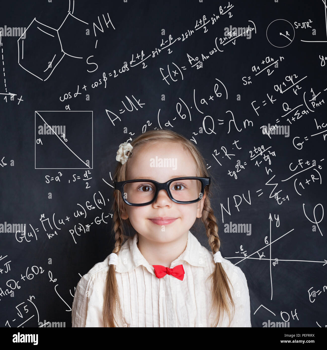 Pequeño genio. Niña inteligente estudiante de matemáticas en la escuela pizarra fondo con
