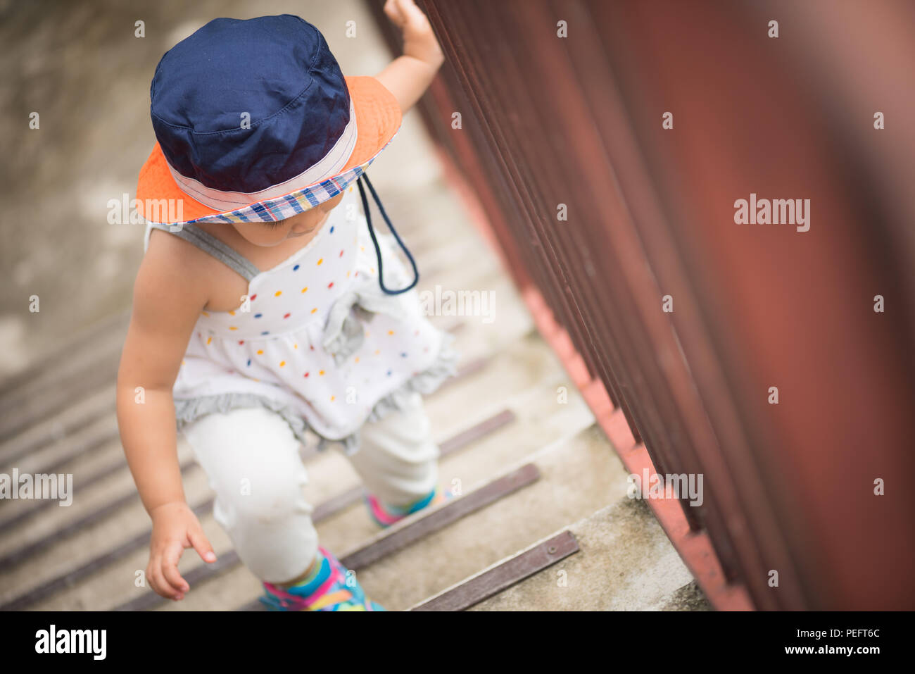 Poco feliz linda chica subiendo las escaleras. Primer paso Kid concepto. Foto de stock