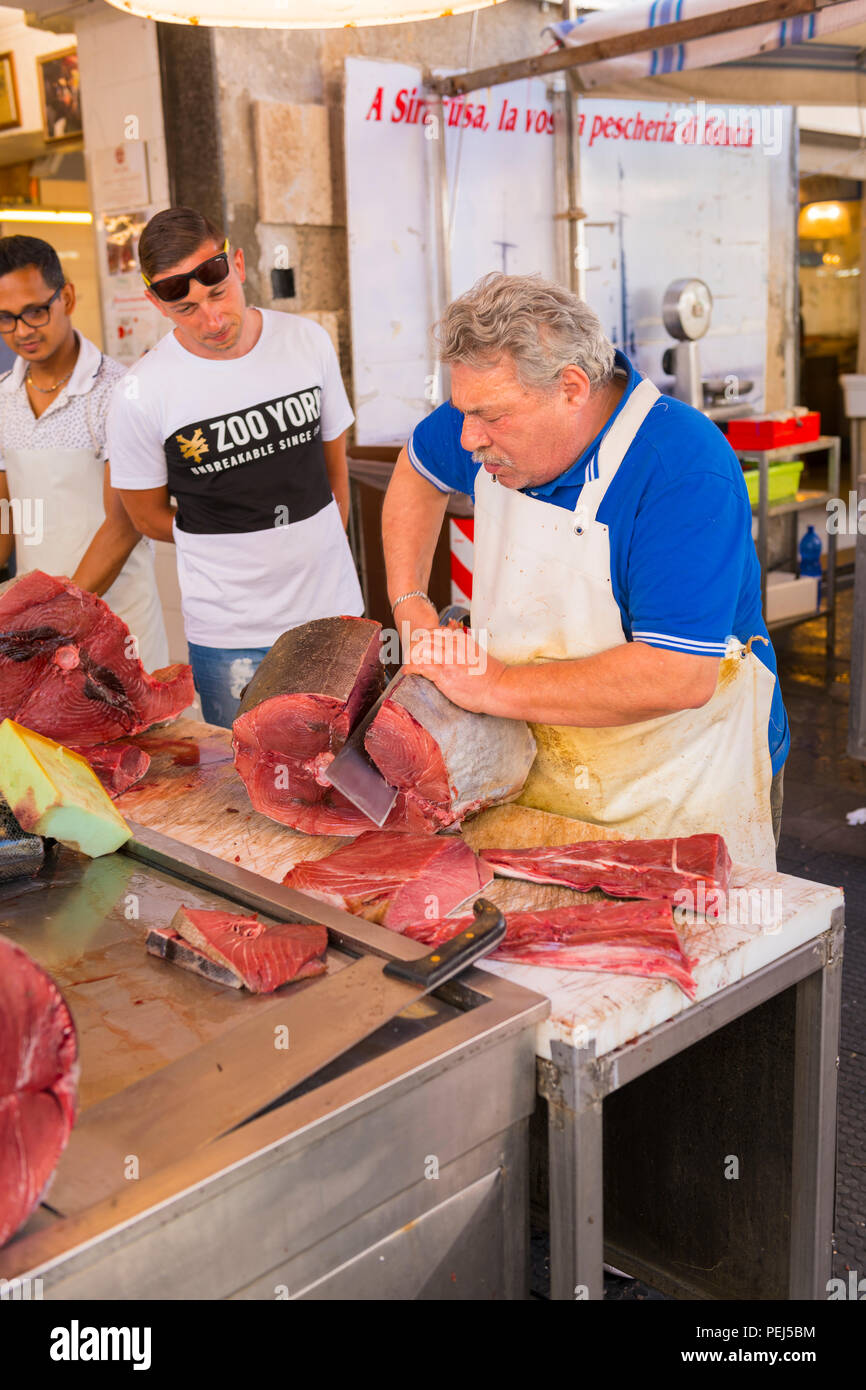 Ortigia Siracusa Siracusa Sicilia Italia histórica calle fresh food & Fish Market pescadero cortar tallar grandes atunes machete contra la cuchilla Foto de stock