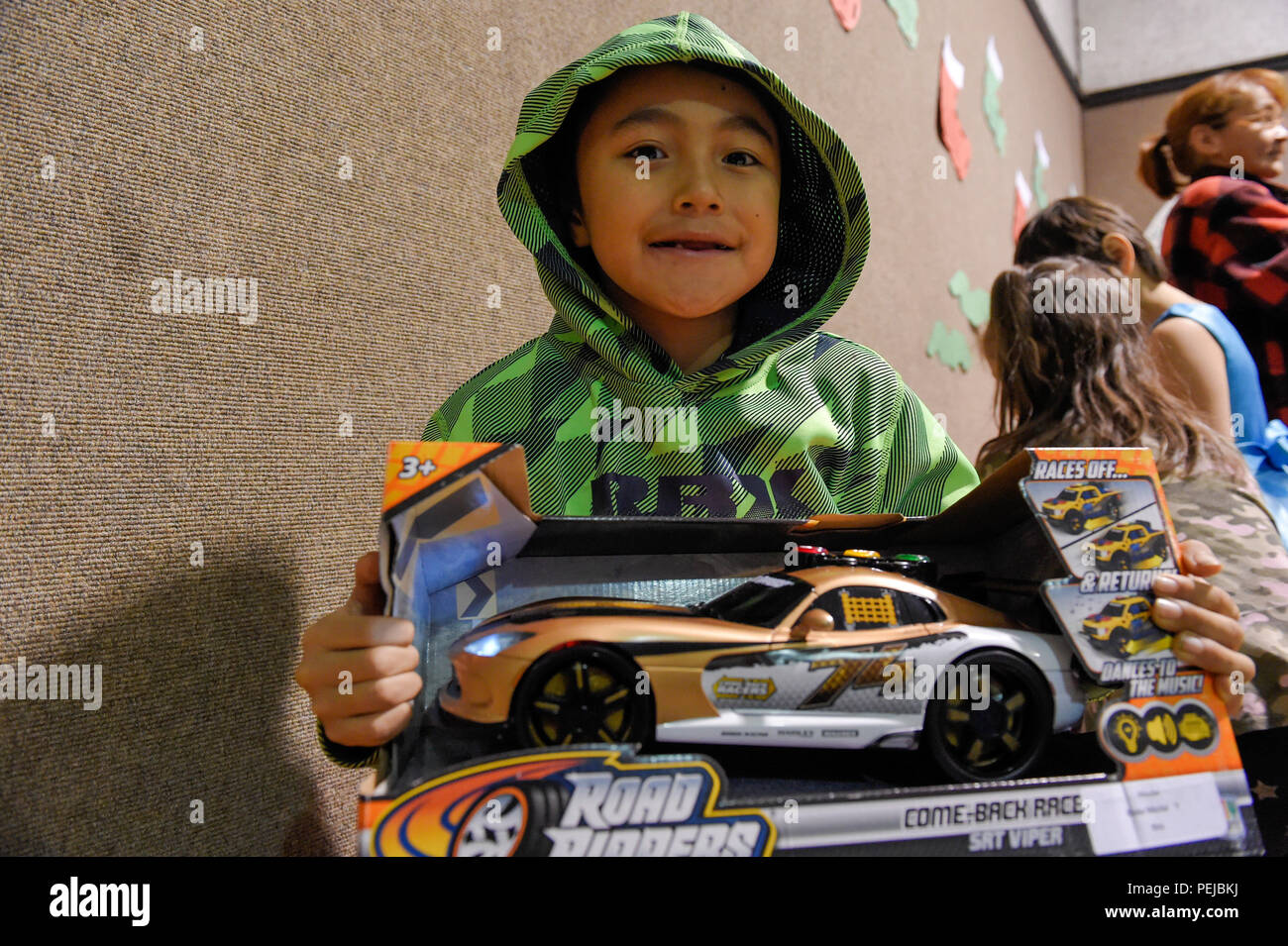 Un niño posa para una fotografía con su nuevo juguete durante Toys for Tots  a Nikolai, Alaska, el 11 de diciembre de 2015. Toys for Tots es un programa  administrado por la