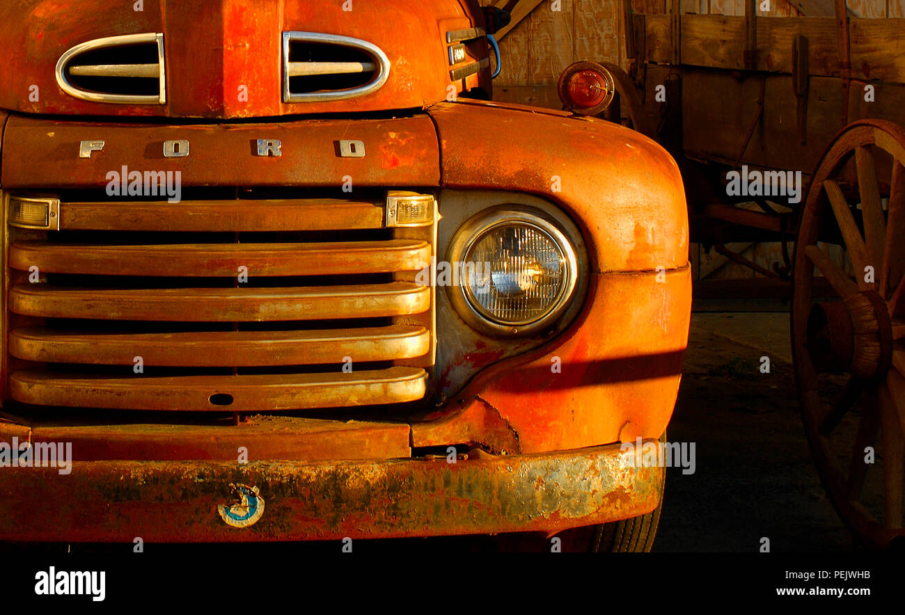 Rojo vieja camioneta Ford aparcado junto a un vagón del viejo oeste. Foto de stock