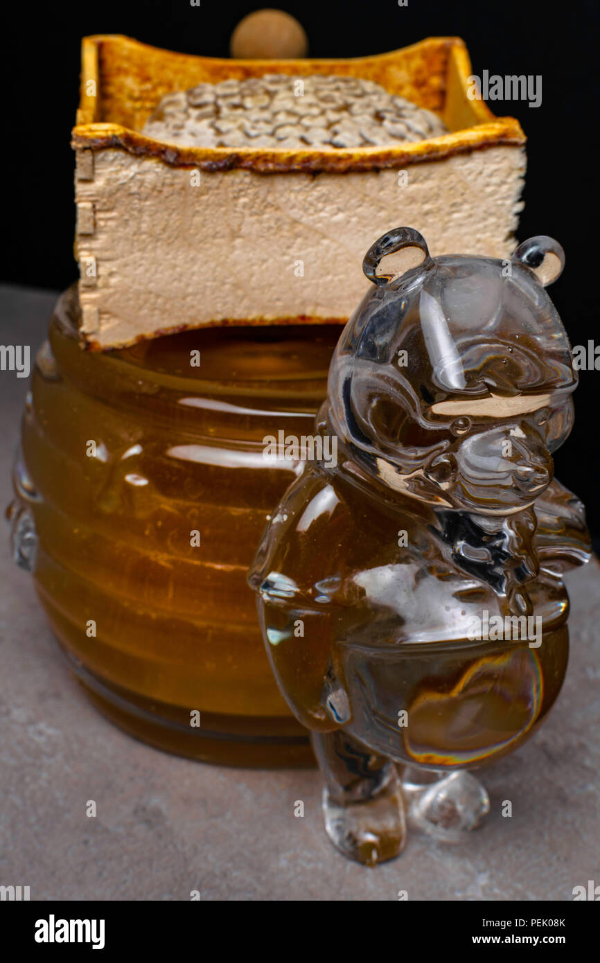 La miel en un recipiente de forma de oso, honeycomb, palo de Fotografía stock - Alamy