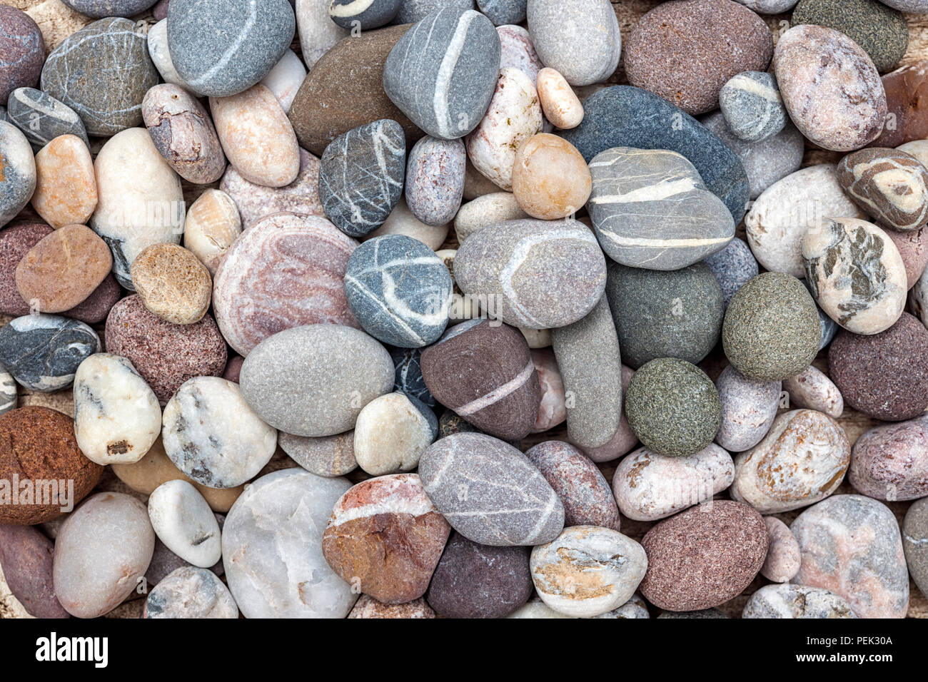 Playa pequeña y redondeada guijarros o rocas lisas con distintos colores y formas de piedras, vista aérea. Foto de stock