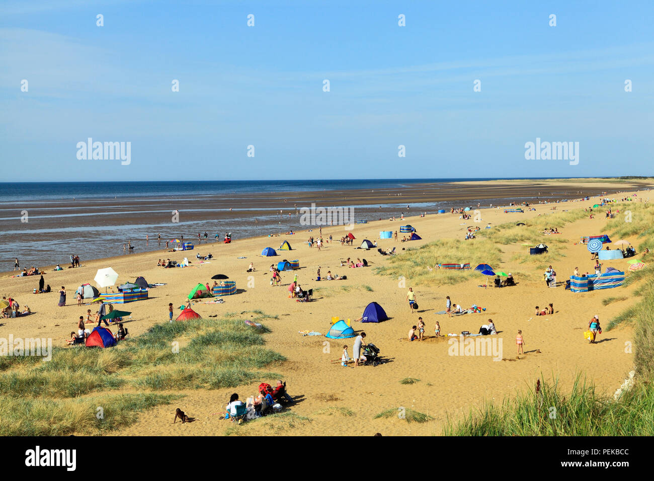 Old Hunstanton, playa, arena, Bahía, bañistas, tumbonas, Mar del Norte, costa, Norfolk, Inglaterra, Reino Unido. Foto de stock