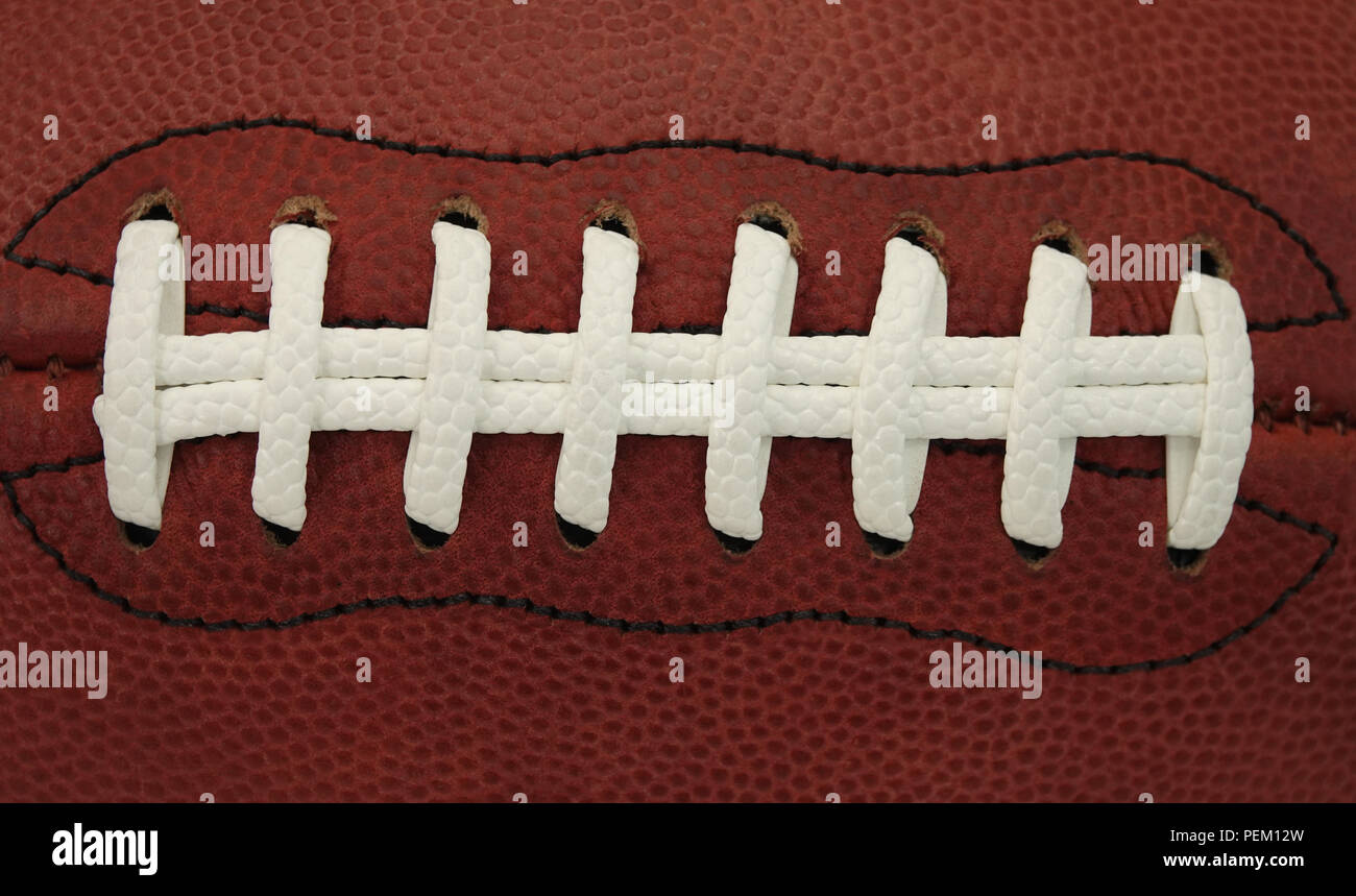 Los cordones y las puntadas de cuero, un juego de pelota de fútbol americano se muestran en una vista de cerca. Foto de stock