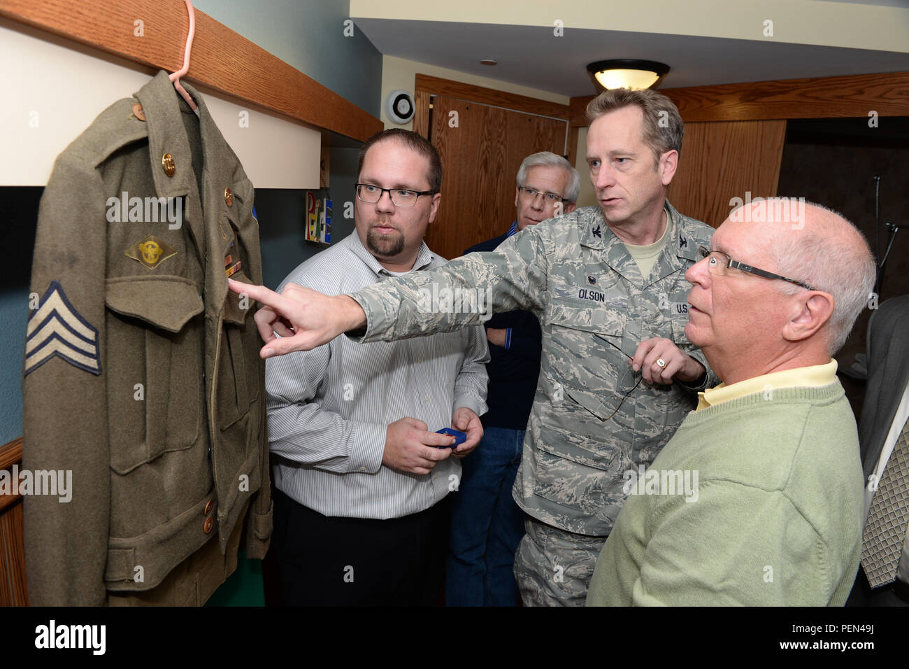El coronel Kent Olson, la 119ª Wing commander, centro, explica el  significado de diversas condecoraciones en el uniforme de veterano de la  Segunda Guerra Mundial Gerald Tillman en el hogar de ancianos