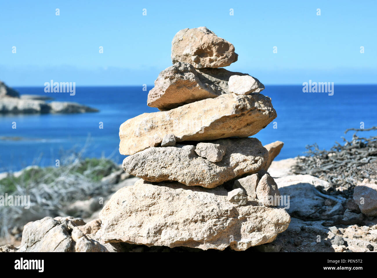 Piedras apiladas o zen stone pila sobre una costa alta con vistas al mar. Foto de stock