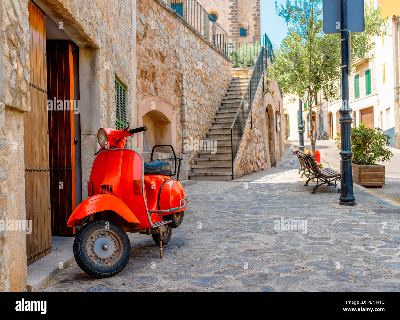 Vintage motocicleta roja estacionada en la histórica aldea española Foto de stock