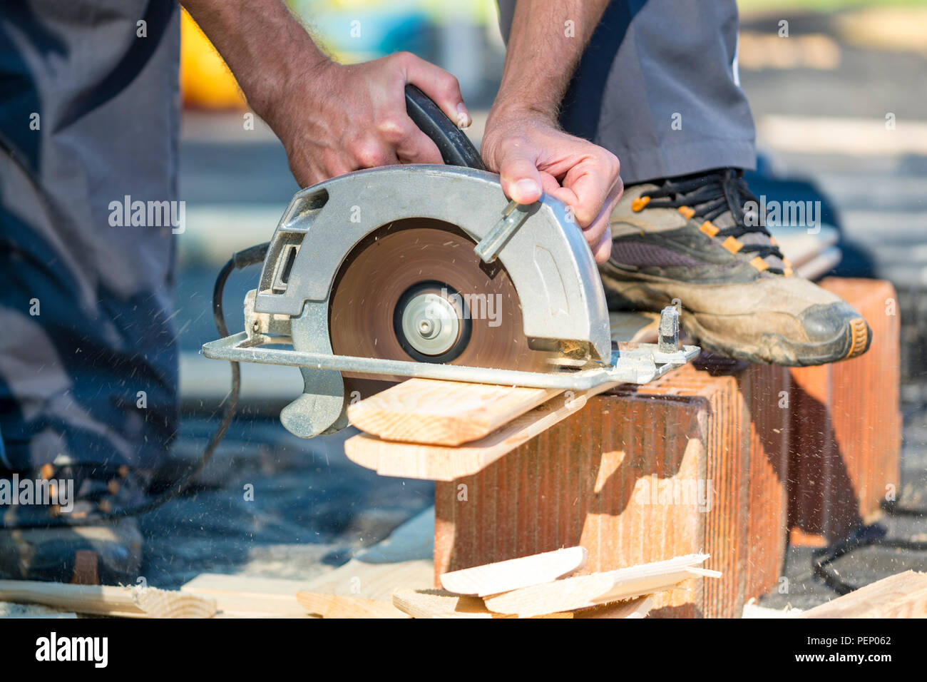 Cierre en inidentificables manos usando una sierra circular para cortar los  tablones de madera al aire libre Fotografía de stock - Alamy