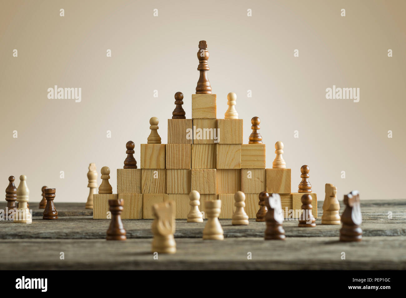 Jerarquía de la empresa, clasificación y concepto de estrategia con piezas  de ajedrez de pie sobre una pirámide de bloques de madera con el rey en la  parte superior con copia Fotografía