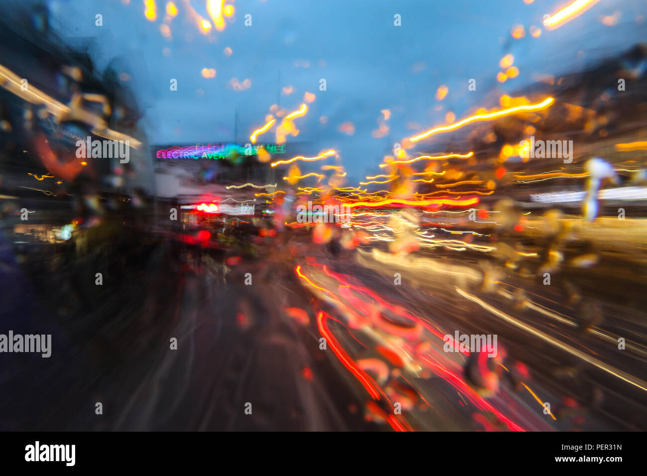 Una imagen desde el bus de conducción en la ciudad durante la noche de la lluvia. Todo es abstracto borrosa en trazas de colores. Foto de stock