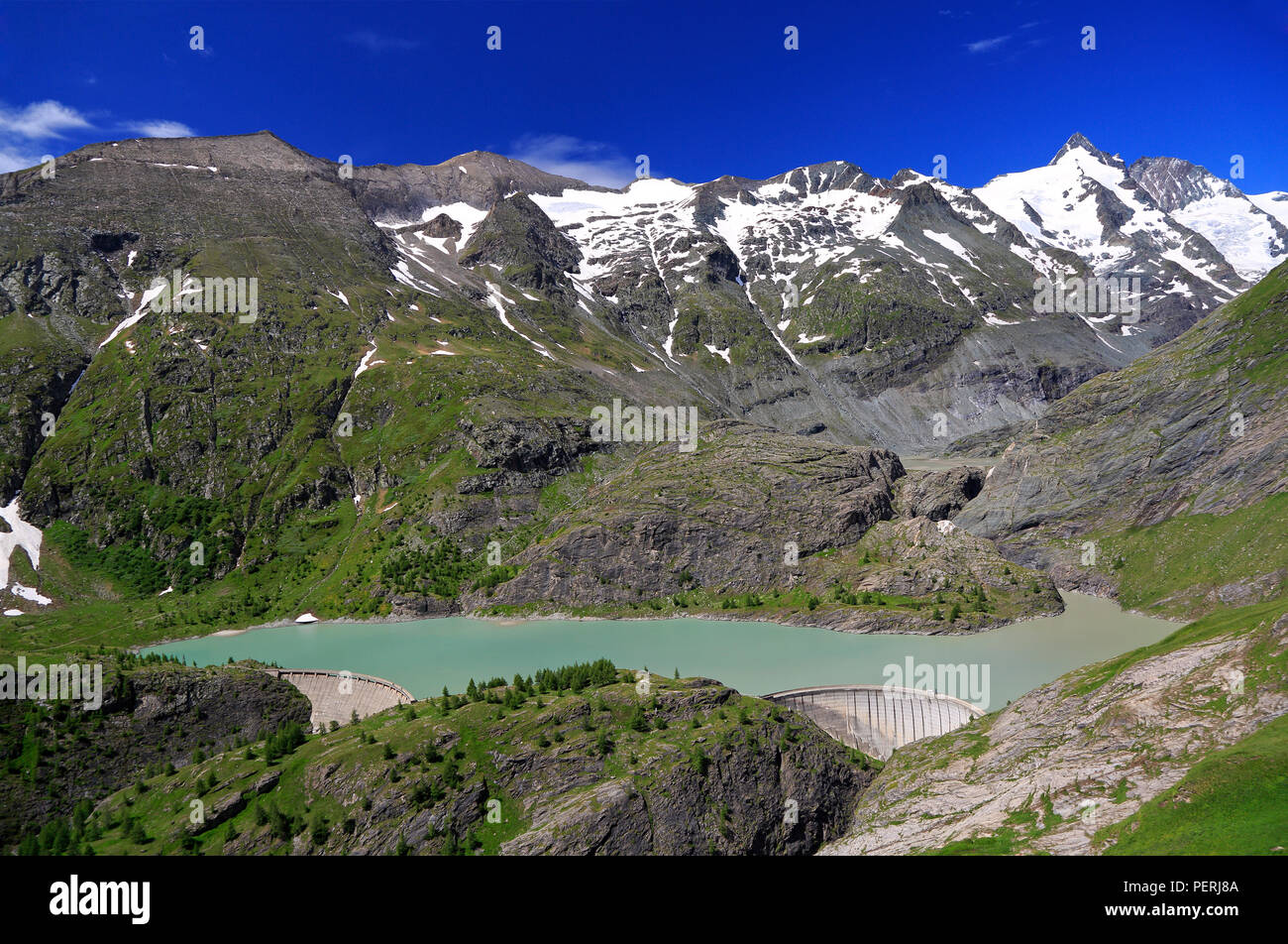 Grossglockner High Alpine Road y cumbre con el lago verde y la presa en primer plano, Austria Foto de stock