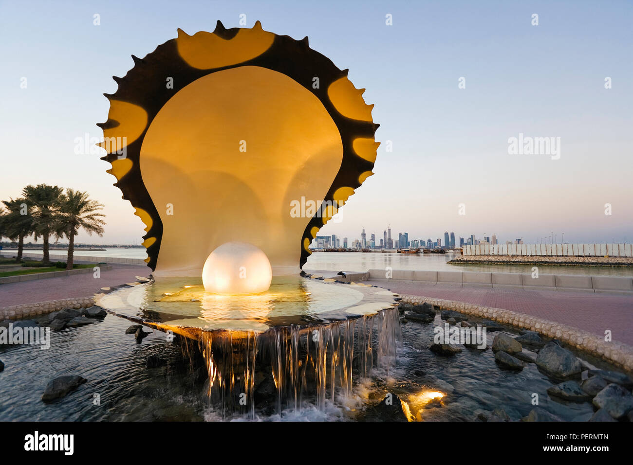 Qatar, en Oriente Medio, la Península Arábiga, Doha, repicar Momument en la Corniche, el Paseo Marítimo de la Bahía de Doha con el distrito de negocios central de West Bay en el horizo Foto de stock