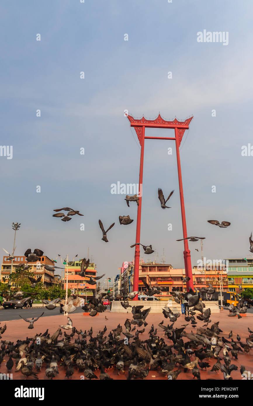 Vintage rojo columpio gigante o Sao Ching Cha con la multitud de palomas, una de las más famosas atracciones turísticas y monumentos en Bangkok, Tailandia. Foto de stock