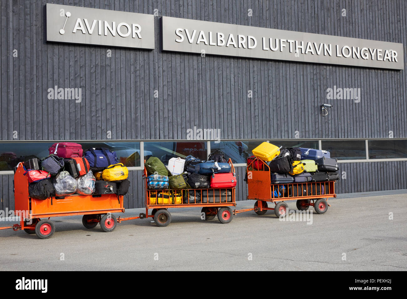 Carros de equipaje están esperando a ser cargado o descargado en el Aeropuerto de Longyearbyen Longyearbyen Svalbard Lufthavn Foto de stock