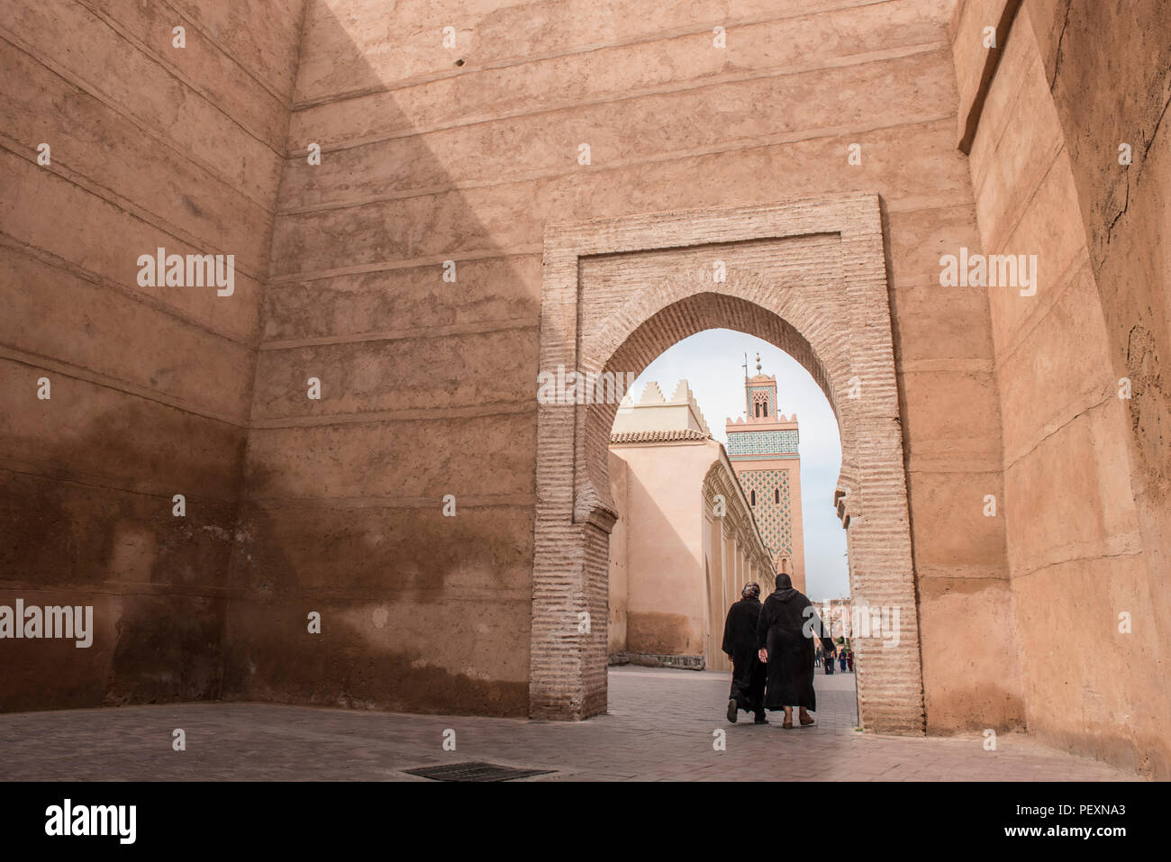 Dos mujeres que caminan a través de arch cerca de Moulay El Yazid Mezquita, Marrakech, Marruecos Foto de stock