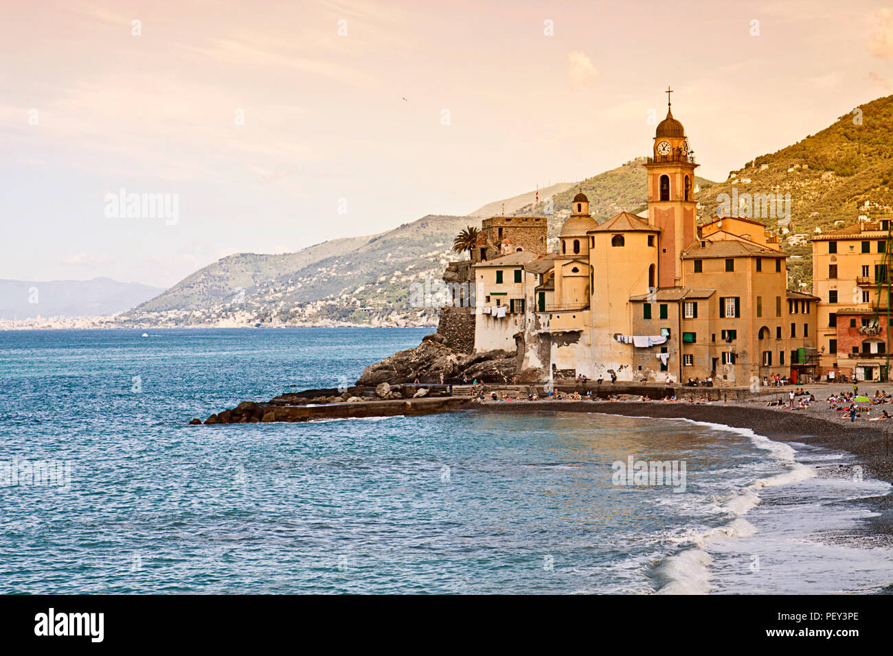 Italia, hermosa vista de Camogli, pueblo de pescadores en la costa ligur, cerca de Génova, con la iglesia de Santa Maria Assunta prominente en el mar Foto de stock