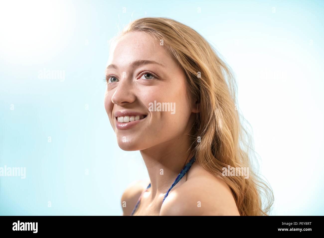 Mujer en la luz del sol, sonriendo. Foto de stock