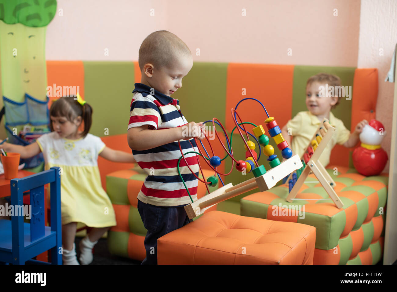 Un grupo de niños jugando en el jardín de infantes o guardería Foto de stock