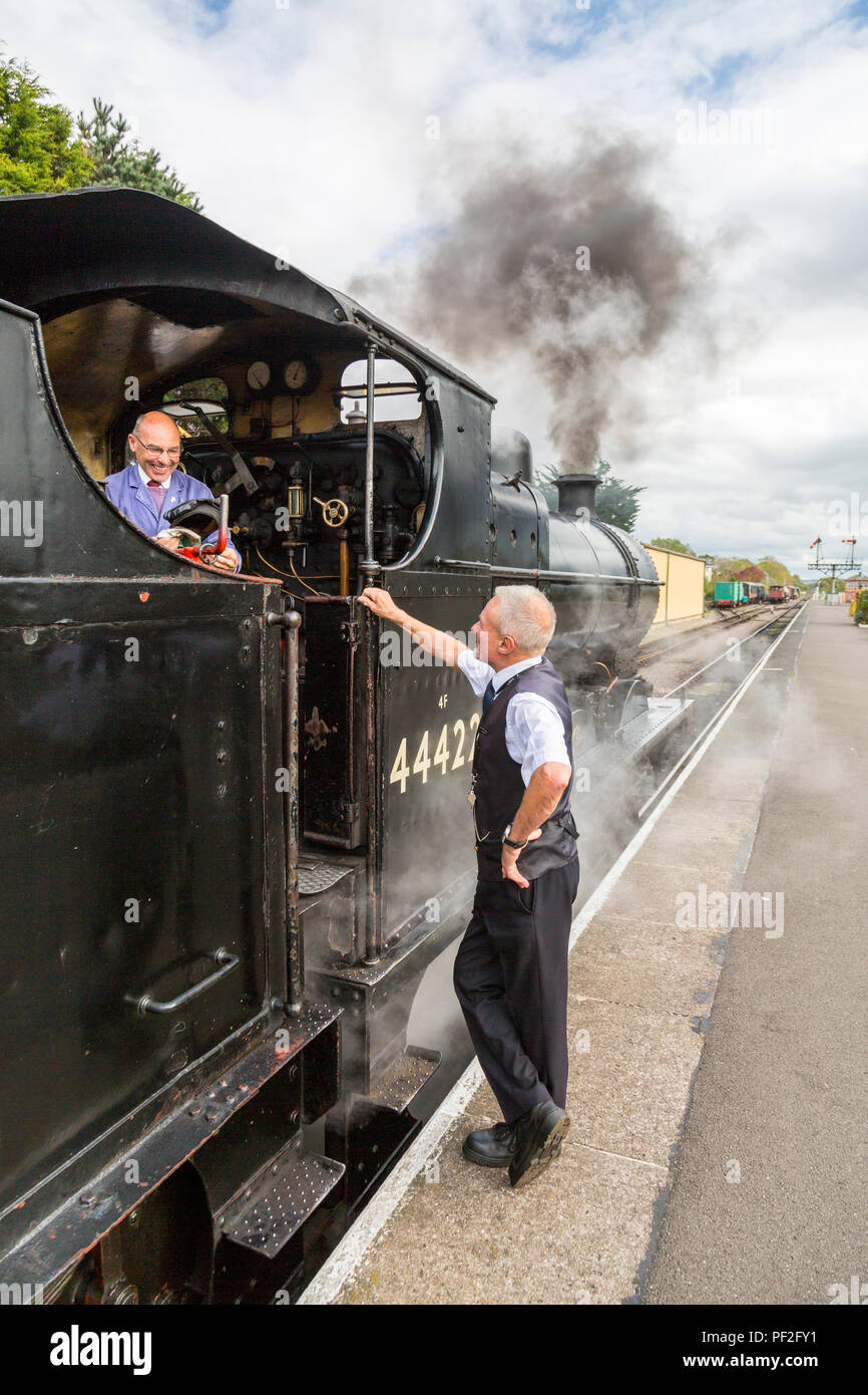 El conductor y el guardia de un tren de vapor antes de la salida del chat en Minehead en la estación de tren West Somerset, Inglaterra, Reino Unido. Foto de stock