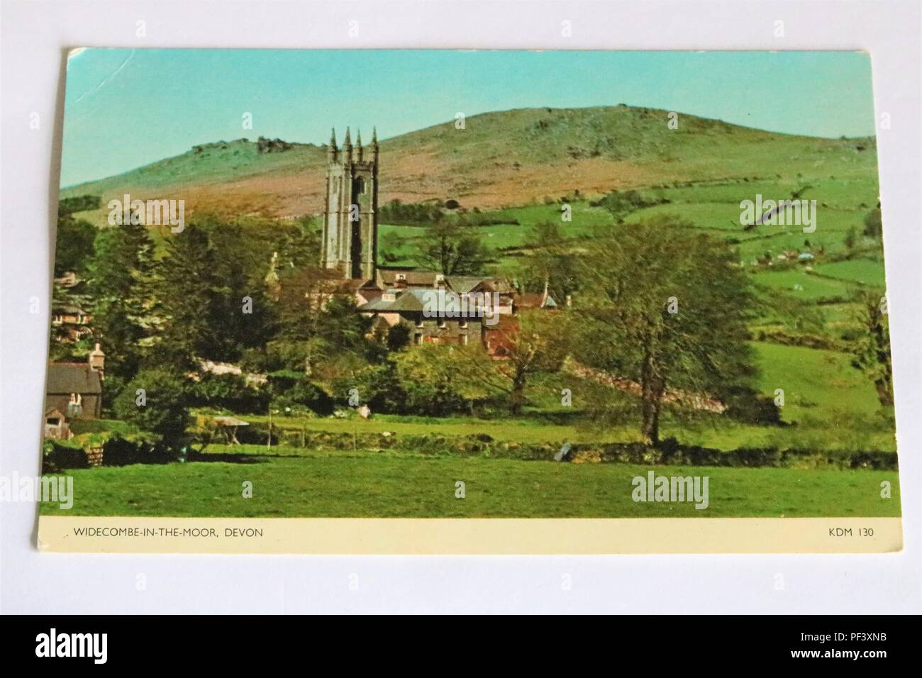 Fotografía en color temprano postal mostrando Widecombe-en-el-Moor, Devon, Reino Unido, con la iglesia y el verde paisaje de campos Foto de stock