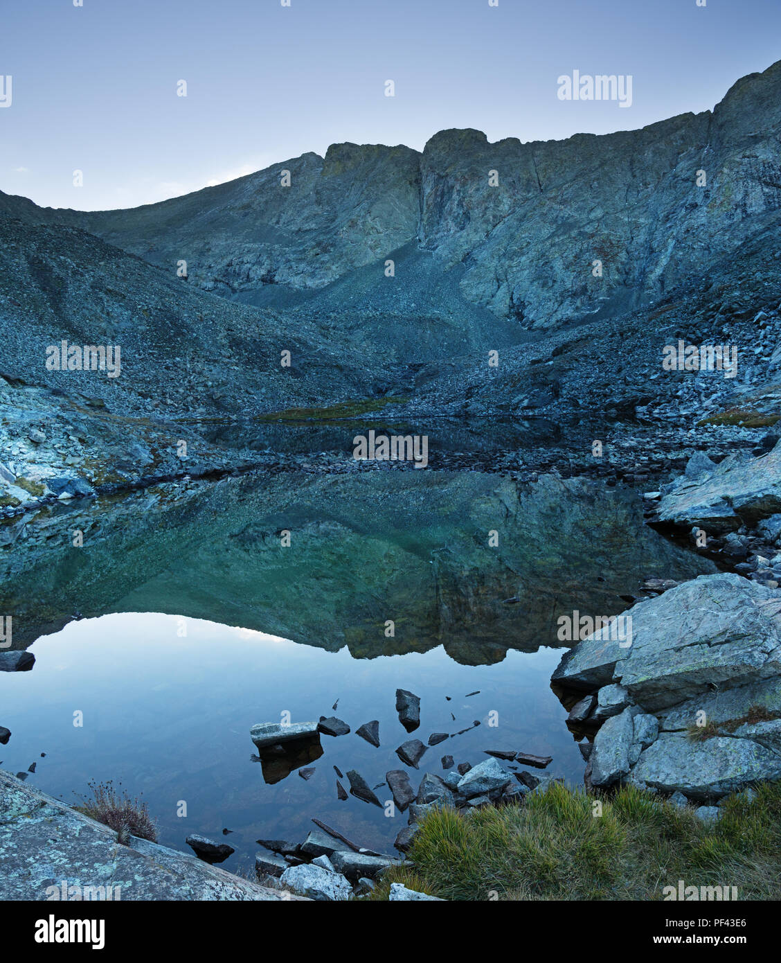 Pico blanca refleja todavía en un lago de montaña Foto de stock