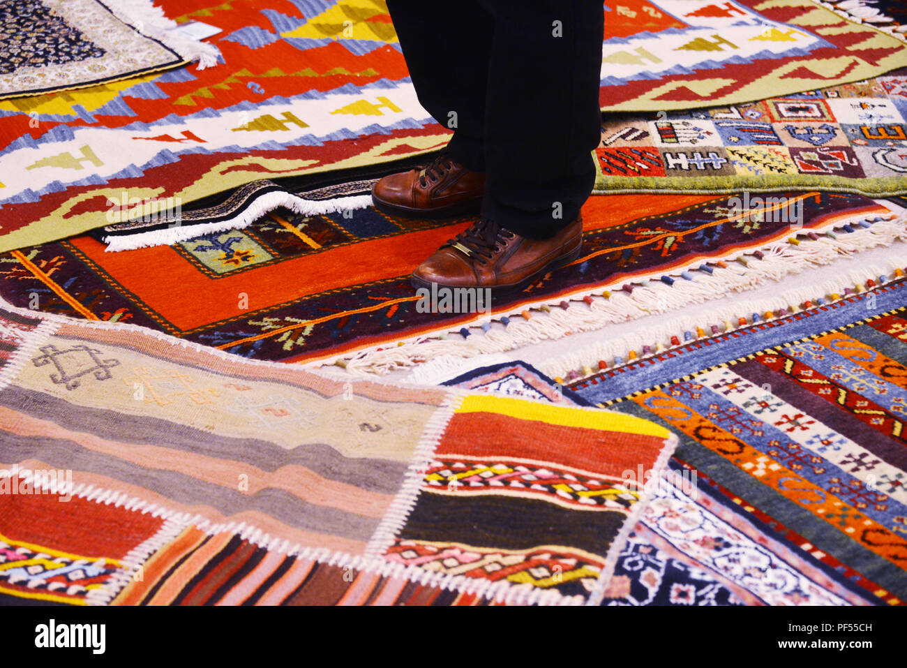 Hombre de pie sobre alfombras turcas en tienda de alfombras Foto de stock