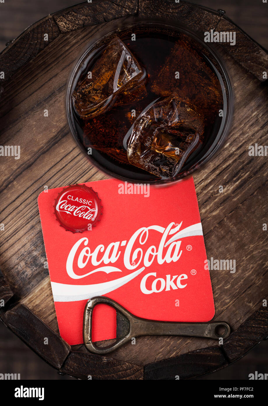 Londres, Reino Unido - Agosto 10, 2018: Posavasos de refrescos Coca Cola original con la parte superior de la y el abresurcos y original de vidrio en la parte superior del