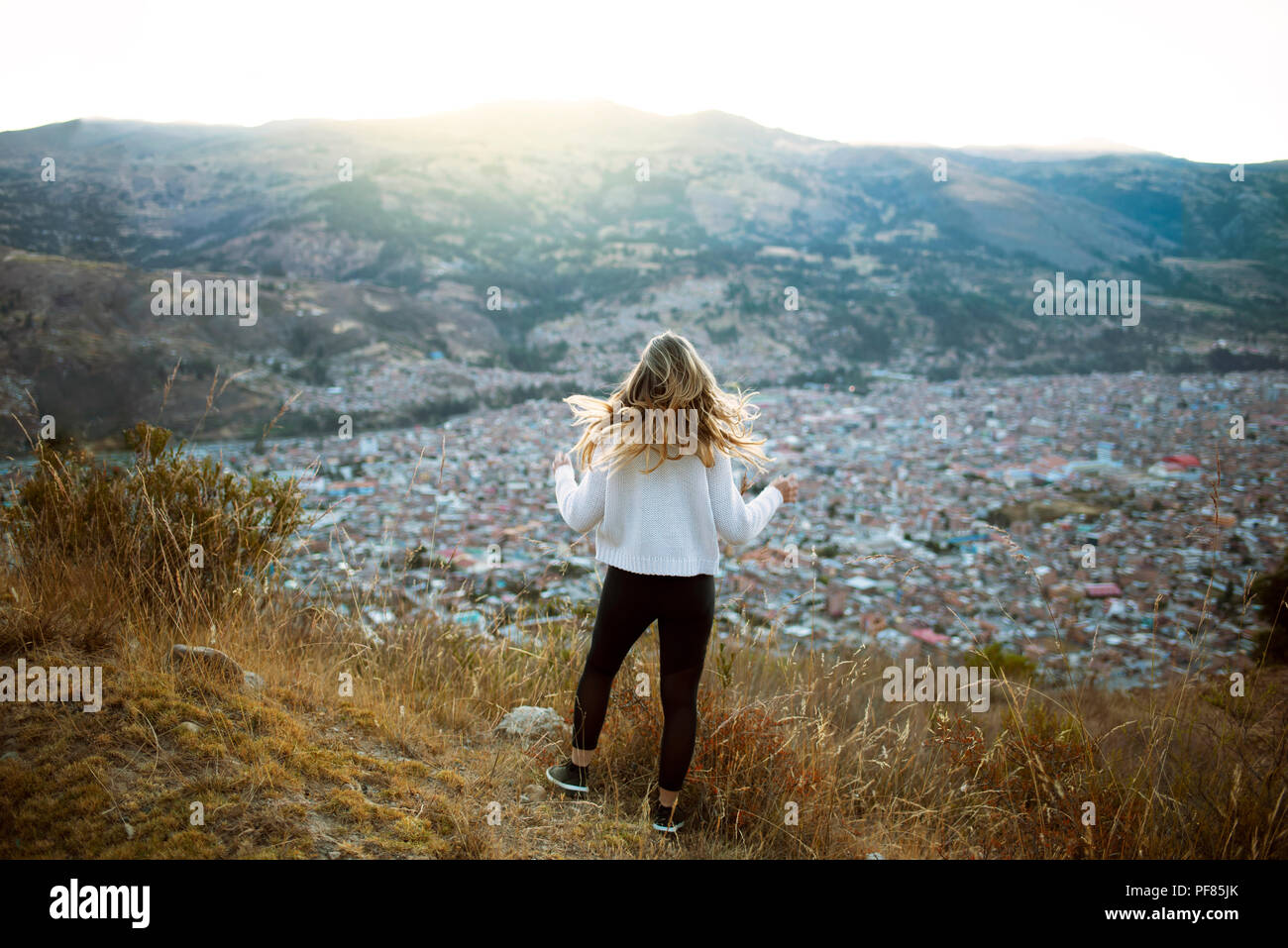 Chica rubia desde atrás mirando a la vista de la ciudad de Huaraz, Perú. Los viajes, el estilo de vida al aire libre, wanderlust, franco de la fotografía. América del Sur. Jul 2018 Foto de stock