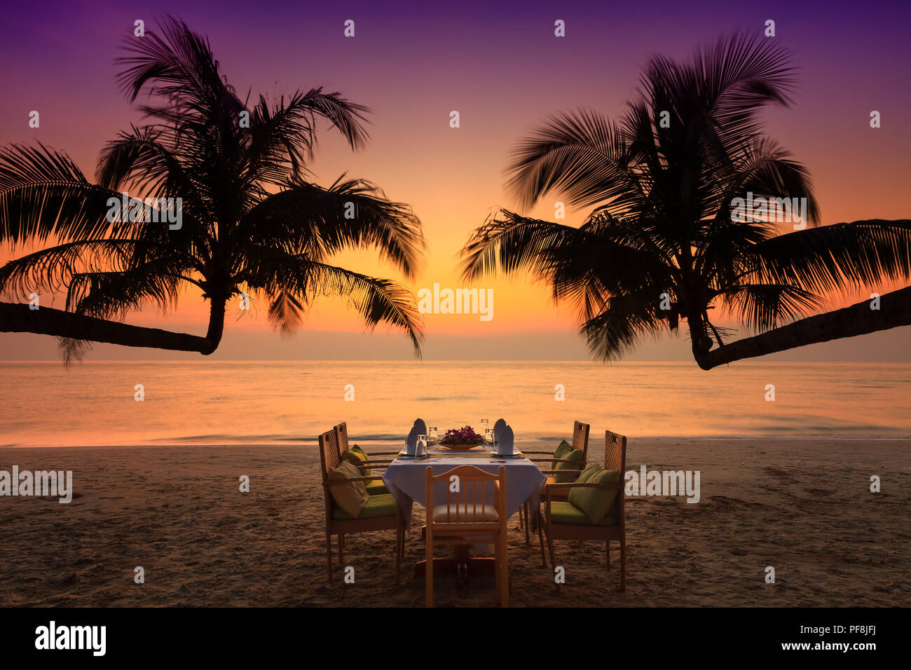 Cena romántica en la playa al atardecer tropical Foto de stock