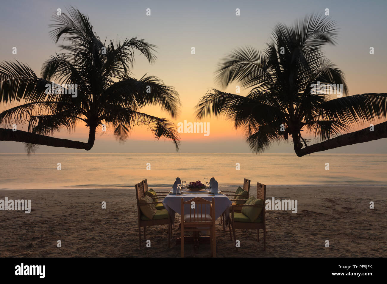 Cena romántica en la playa al atardecer tropical Foto de stock