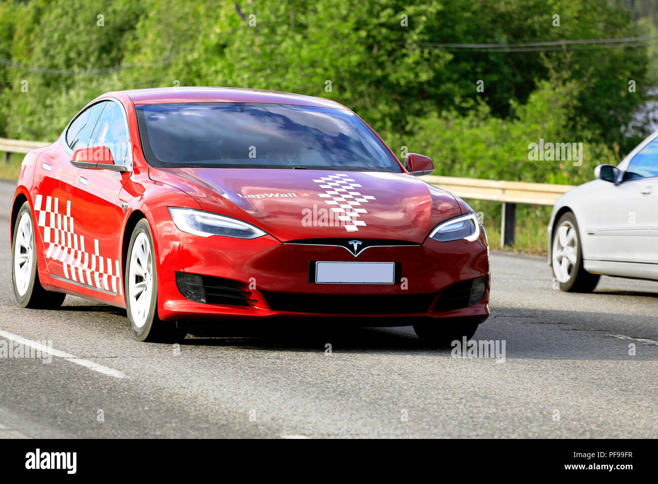 Jyväskylä, Finlandia - Junio 15, 2018: rojo y blanco modelo Tesla S coche eléctrico del nuevo diseño exterior en velocidad en la carretera entre el tráfico en el verano. Foto de stock