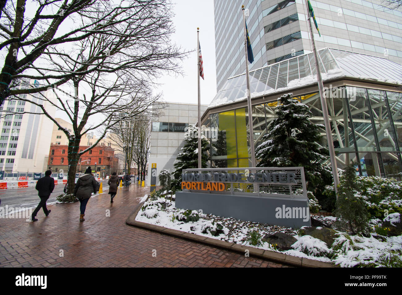 PORTLAND, Oregon, el 21 de febrero de 2018: gente que camina más allá de un edificio del World Trade Center en Portland, en una mañana de invierno con nieve en el suelo. Foto de stock